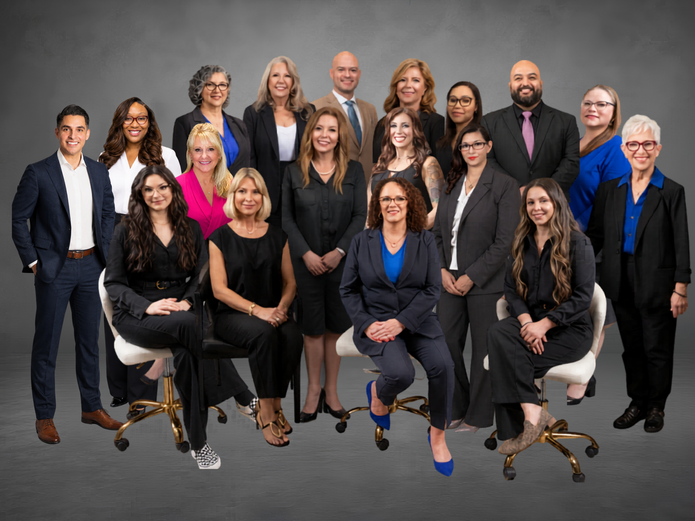 Group of diverse professionals posing together in a studio, wearing business attire against a gray backdrop.