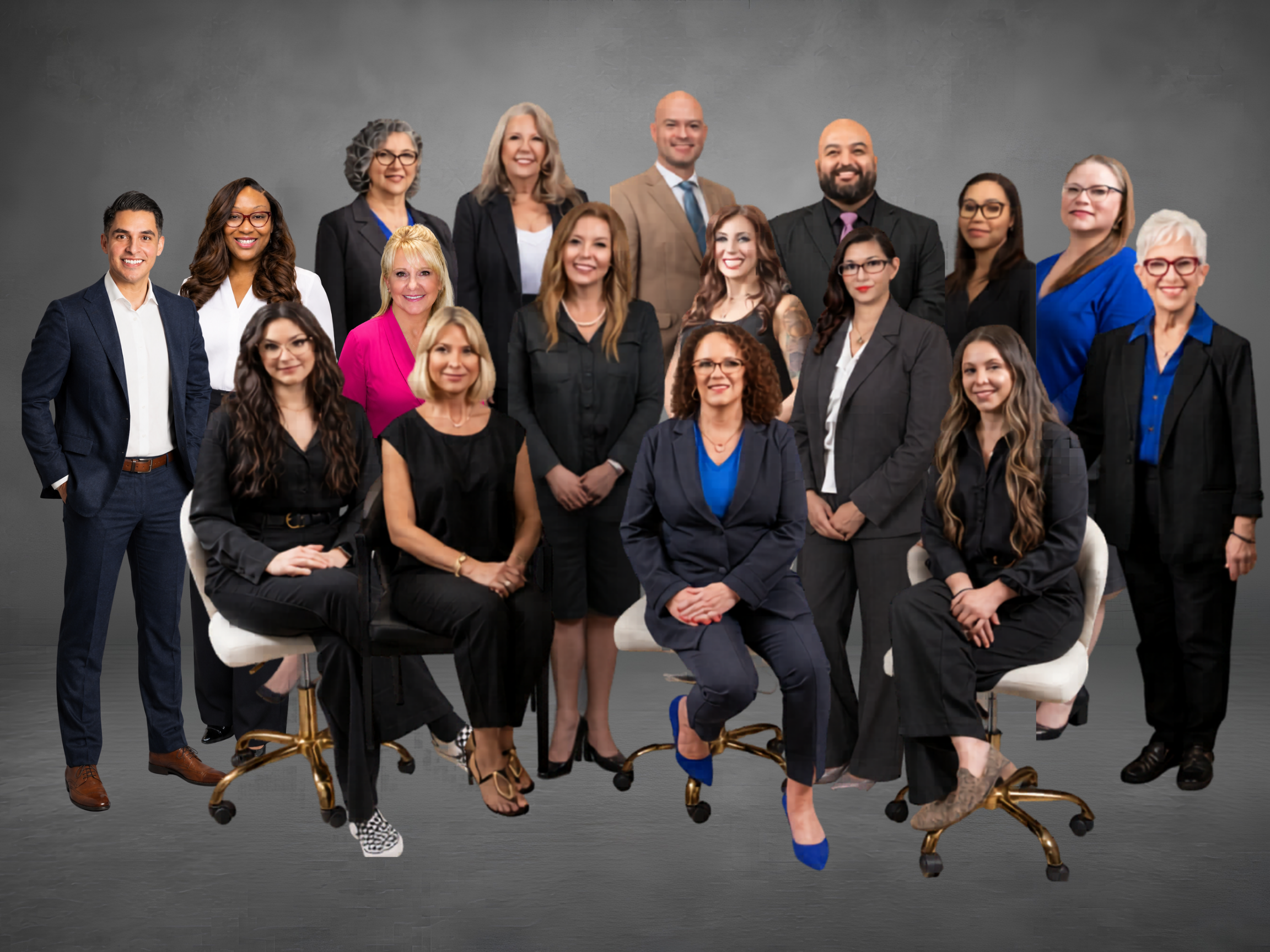 Group of diverse professionals posing together in a studio, wearing business attire against a gray backdrop.